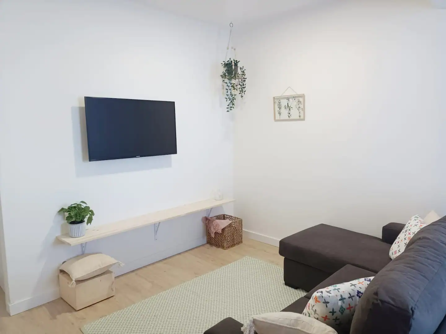 sofá, alfombra y televisor del apartamento turístico A Capelada, en Cedeira